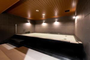 een grote badkamer met een groot bad met verlichting bij First Cabin Ichigaya in Tokyo