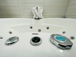 a white bath tub with two knobs in a bathroom at Hotel Aquetzalli in Cocoyoc