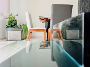 - un salon avec une table et des chaises en verre dans l'établissement Hotel Aquetzalli, à Cocoyoc