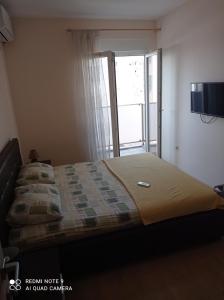 a bed in a bedroom with a sliding glass door at Apartment Ana in Podgorica