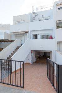 a white building with a staircase in front of it at La Terraza de Agua Amarga in Agua Amarga