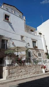 - un bâtiment blanc avec un parasol devant dans l'établissement Torre Pendio b&b, à Corato