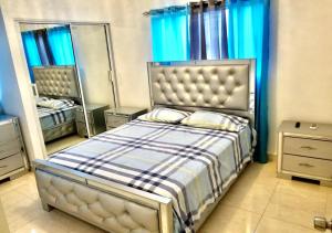 a bedroom with a bed and two mirrors at Bello y comodo apartment , residencial con piscina, seguridad las 24 Horas in Licey al Medio