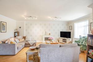 a living room with two couches and a tv at 8 Tywod Arian in Morfa Nefyn