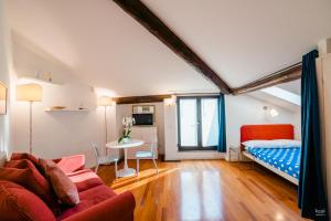 uma sala de estar com uma cama e uma mesa em FEEL - Central Terrace em Bérgamo
