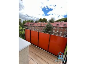 an orange fence on a balcony with buildings in the background at Vintage room in Gdańsk