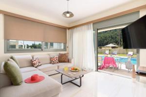 a living room with a couch and a table at Villa Paleos Hillside by Villa Plus in Ialysos