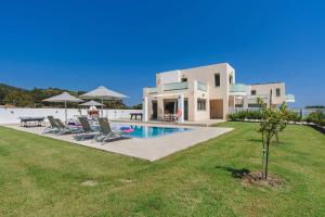 a villa with a swimming pool and a house at Villa Paleos Hillside by Villa Plus in Ialysos