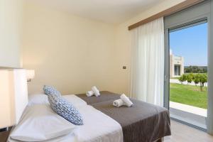a bedroom with a bed with two stuffed animals on it at Villa Paleos Hillside by Villa Plus in Ialysos +13 photos