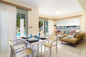 un soggiorno con tavolo e sedie di Villa Paleos Evergreen by Villa Plus a Ialyssos