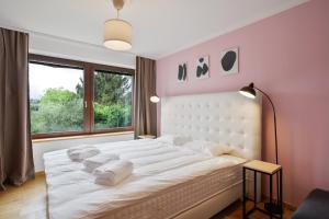 1 dormitorio con 1 cama blanca grande y ventana en Apartmány Mind Adventure, en Lštění
