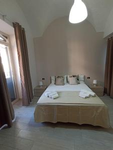 um quarto com uma cama grande e toalhas em Vittorio Emanuele house em Catânia