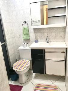 a bathroom with a sink and a toilet and a mirror at Apartamento Mobiliado em Limeira in Limeira