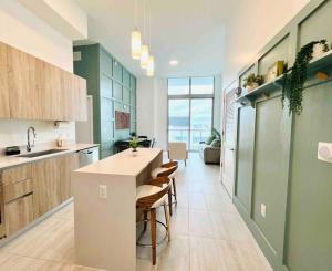 a kitchen with a counter and chairs in a room at Sleek 2BD 2BA Condo In Miami Design District in Miami