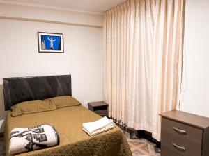 a bedroom with a bed and a dresser and a window at Apart La Merced in Caraz