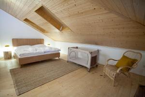 a bedroom with a bed and a chair and a wooden ceiling at Apartmány Mind Adventure in Lštění