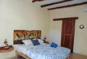 1 dormitorio con 1 cama con una pintura en la pared en Art Maya Rooms, en Isla Holbox