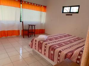 een slaapkamer met een bed, een tafel en een raam bij Hotel Puerto Villamar in Tepoztlán