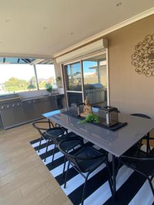 een eetkamer met een blauwe tafel en stoelen bij "WATERLILY HOUSE" - Luxury Canal House, Jetty, Dog & Child Friendly - Sleeps 14 in Mandurah