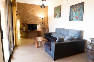 a living room with a couch and a tv at Tenerife Healing Garden in Guía de Isora