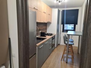 a kitchen with a stainless steel refrigerator and a table at Ghencea Residence 158 L1 in Bucharest