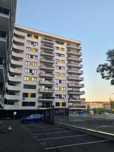 a large apartment building with a car parked in a parking lot at Ghencea Residence 158 L1 in Bucharest
