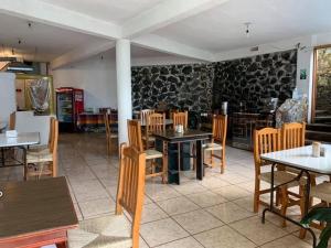 a restaurant with tables and chairs in a room at Hotel Puerto Villamar in Tepoztlán