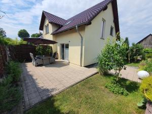 un patio con sombrilla junto a una casa en Ferienwohnung relax, en Ostseebad Koserow
