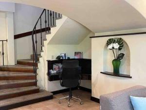 a living room with a desk and stairs with a chair at 3 Bedroom Villa in Hacienda Pinilla in Tamarindo