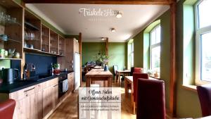 eine Küche mit einem Tisch, Stühlen und einer Theke in der Unterkunft Triskele Haus - Ökologisches Seminar- und Gästehaus in Strelitz in Neustrelitz