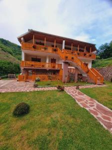 ein großes Haus mit einer großen Terrasse an der Seite in der Unterkunft Kuca Stojanovica Topli Do in Pirot