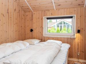 um quarto com paredes de madeira e uma janela em Holiday home Oksbøl LXXXIII em Oksbøl
