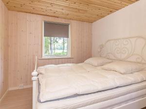 a white bed in a room with a window at 6 person holiday home in Læsø-By Traum in Læsø