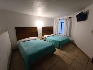 a hotel room with two beds and a window at El Arrayan in Valle de Bravo