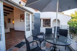 a patio with a table and chairs and an umbrella at Domaine Saint Laurent in Béziers