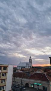 un edificio con una torre de reloj en la cima de una ciudad en Apartament Central, en Gherla 7 fotos más