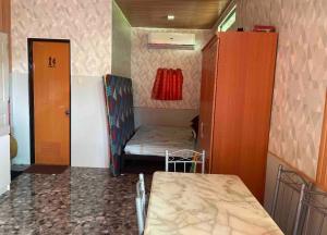 Habitación pequeña con cama pequeña y armario en KeCai’s Place en Digos