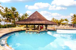 una gran piscina con un pabellón de paja en Sauipe Resorts Ala Terra - All Inclusive, en Costa do Sauipe