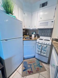 uma cozinha com um frigorífico branco e um fogão em Sun Splashed Condo! Steps to Beach and 2 Pools Galveston Island em Galveston