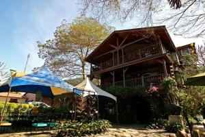 a house with a blue and white tent in front of it at Sun Moon Lake Full House Resort in Yuchi