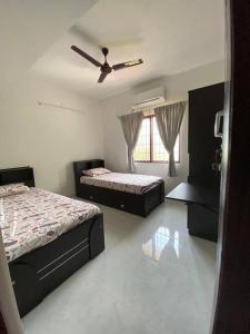 um quarto com 2 camas e uma ventoinha de tecto em AR Springfields(1), amidst lush green scenic view em Manipal