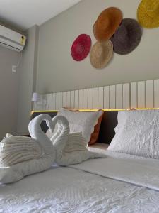 dois cisnes feitos de toalhas numa cama em Gran Lençóis Flat Barreirinhas Apt 509 em Barreirinhas