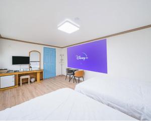 a bedroom with a bed and a desk and a tv at Top Island Hotel in Jeju +27 photos
