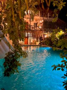 a large swimming pool with blue water at night at Hotel Jaiba Mahahual - Adults Only in Mahahual