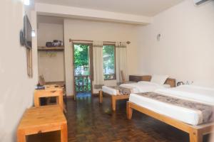 um quarto com 2 camas, uma mesa e uma janela em Chitwan Paradise Hotel em Sauraha