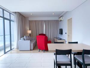 een woonkamer met een tafel en rode stoelen bij Straits Suite by C Homestay Malacca in Melaka