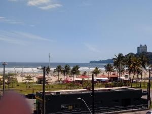a view of a beach with palm trees and a bus at Revigore-se e desfrute o que a vida tem de bom in São Vicente