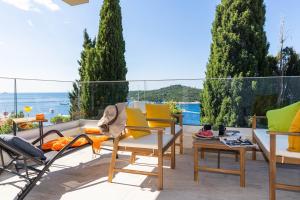 eine Terrasse mit Stühlen und Tischen und Meerblick in der Unterkunft Magic Fantasy in Dubrovnik