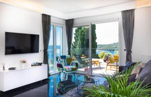 ein Wohnzimmer mit einem TV und einem großen Fenster in der Unterkunft Magic Fantasy in Dubrovnik