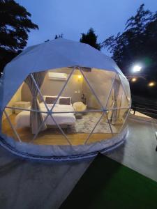 een ronde tent met een bed in de nacht bij นรดีฮิวล์ รีสอร์ต เขาแผงม้า วังน้ำเขียว in Ban Sap Bon